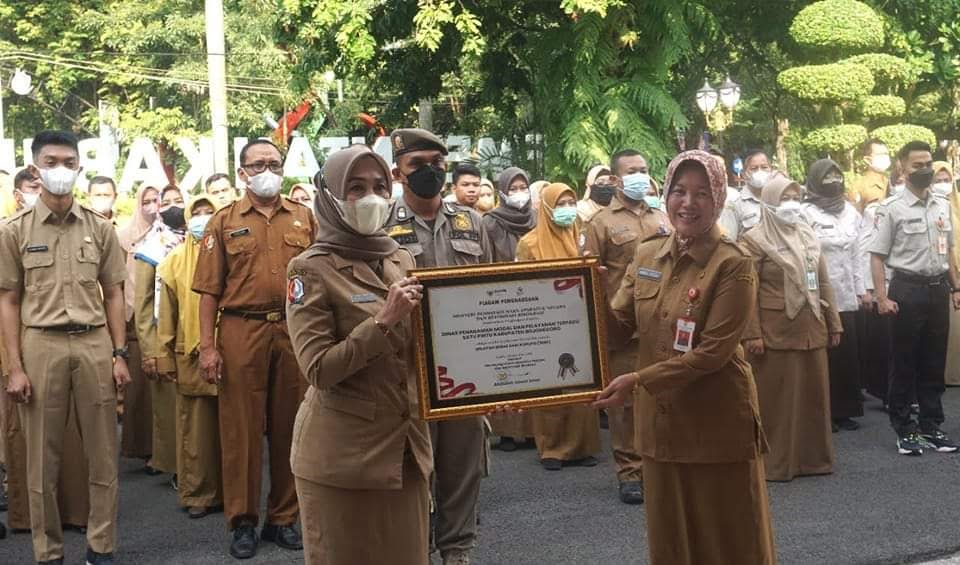 PENGHARGAAN: Sekda Bojonegoro Nurul Azizah menyerahkan piagam penghargaan kepada Kepala DPMPTSP Yusnita Liasari saat apel di Halaman Pendopo Malowopati