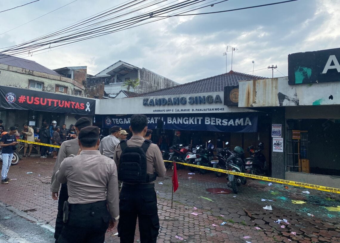 DIJAGA: Pihak Kepolisian Polresta Malang Kota saat melakukan penjagaan di TKP pasca peristiwa perusakan kantor Arema FC Malang