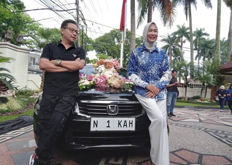 MOBIL : Walikota Malang Drs H Sutiaji foto bersama dengan Ketua Tim Penggerak PKK Kota Malang Ny Widayati Sutiaji swa foto di depan mobil Dinas Walikota Malang N 1 KAH. (Suaragong/man)