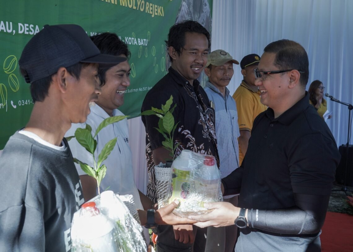 Pj Walikota Batu Aries Agung Paewai menyerahkan bibit kopi pada warga Dusun Brau Gunungsari. ( suara gong/ist)