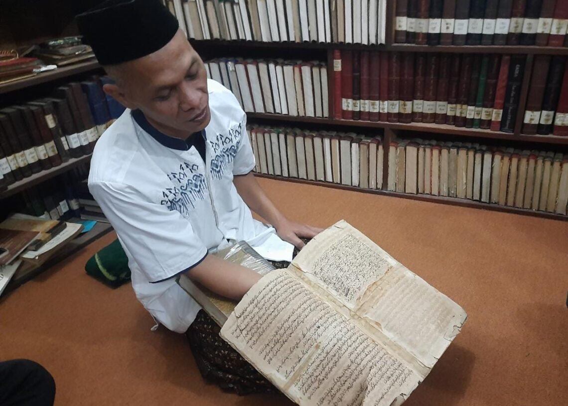 Gus Adlan, menunjukkan kitab tulisan tangan Mbah Hasyim Asyari, yang berusia ratusan tahun.(Suaragong)