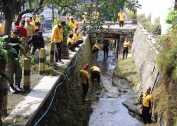 Anggota Polres Batu bersih-bersih sungai di depan JTP 3. (ist)