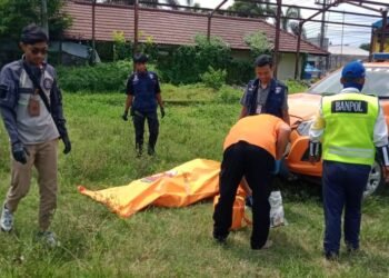 FT. Relawan sedang mengevakuasi jenazah dari lahan kosong. (ist)