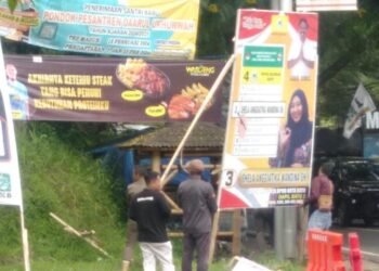 Ft : Anggota Bawaslu dan Sat Pol PP Kota Batu melakukan penertiban APK langgar aturan, Jumat (2/2) kemarin.