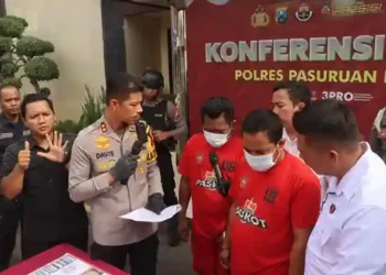 Dua pria di Pasuruan harus berurusan dengan pihak kepolisian setelah tertangkap basah bermain judi online jenis slot di teras rumah mereka.