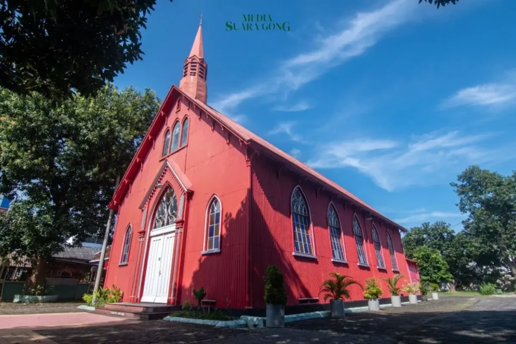 gereja tua probolinggo berwarna merah terang dengan gaya arsitektur klasik Eropa yang begitu kontras dengan suasana tropis Indonesia