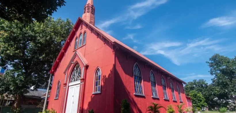 gereja tua probolinggo berwarna merah terang dengan gaya arsitektur klasik Eropa yang begitu kontras dengan suasana tropis Indonesia