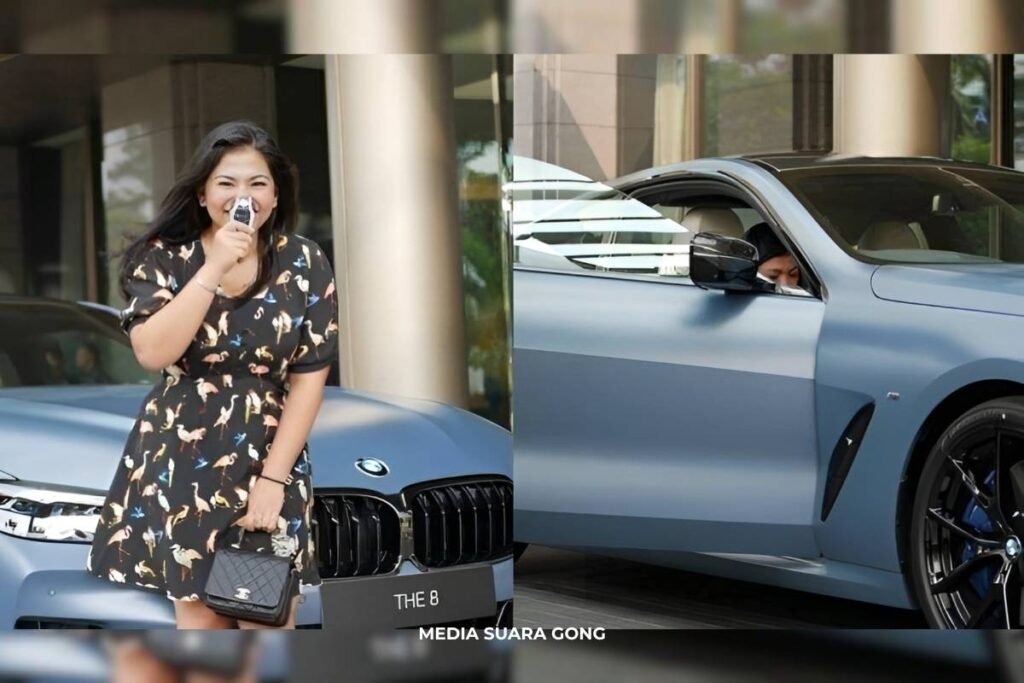 Liana Saputri tersenyum sambil memegang kunci BMW M850i di depan mobil mewah berwarna Frozen Barcelona Blue, menunjukkan kebahagiaan setelah menerima kendaraan edisi langka.