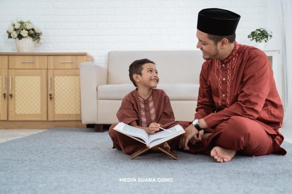 bapak dan anak mengaji bersama sambil tertawa menggunakan pakaian berwarna coklat dan duduk di bawah Libur Tahun Baru Islam
