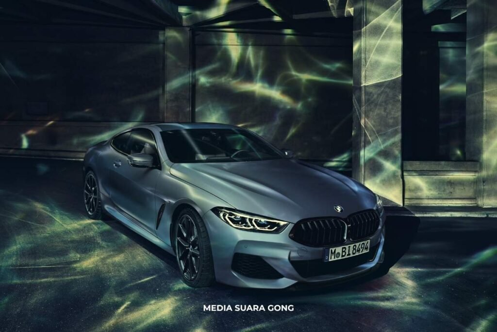 BMW M850i First Edition diparkir di ruang temaram dengan efek cahaya unik.