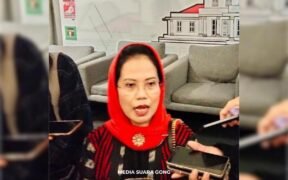Dr.Sri Untari Bisowarno,M.AP menggunakan kerudung warna merah yang sedang diwawancarai oleh wartawan terkait kunjungan masyarakat desa