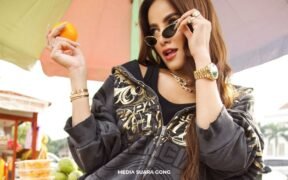 olla ramlan lepas hijab dan berpose waktu pemotretan sambil pegang jeruk pake kacamata, jaket hitam sexy dan cantik
