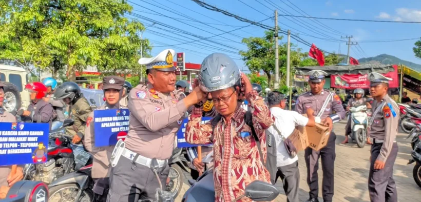 Ft : Kasat Lantas Polres Trenggalek AKP Sony saat memberikan helm kepada pengguna jalan yang melintas