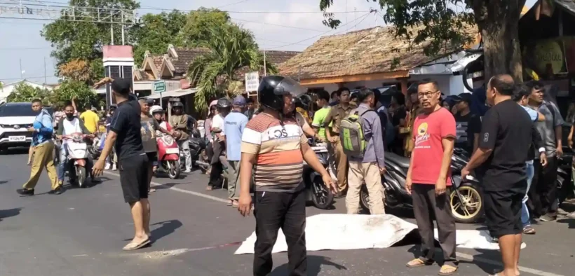 Caption Foto: Warga berkerumun di lokasi kejadian kecelakaan maut yang menewaskan seorang pelajar di Jalan Basuki Rahmat, Kelurahan Mangunharjo, Selasa (15/7/2025). Jenazah korban ditutupi kain sebelum dievakuasi petugas (Grup Facebook ISP -INFO SEPUTAR PROBOLINGGO -).