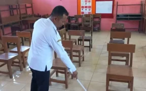 Caption Foto: Seorang guru SDN Warujinggo 2 membersihkan ruang kelas kosong yang tidak terisi siswa baru dalam dua tahun terakhir, Rabu (16/7/2025) (Foto: Farid Fahlevi).
