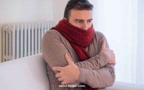 pria pake baju coklat bersyal merah lagi merasakan fenomena bediding