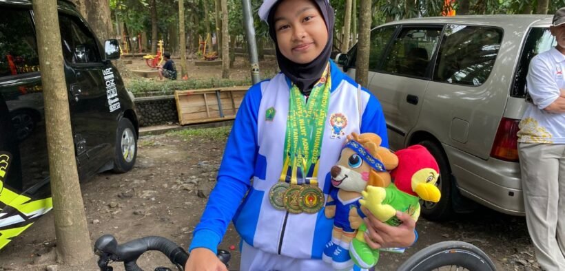 Aila Zahra atlet Malang sabet 3 medali 2 emas 1 perunggu diatas sepeda dan memegang boneka