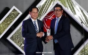 Jahja Setaatmadja berjabat tangan dan memegan piala tapi kabarnya jual 1 juta saham BBCA
