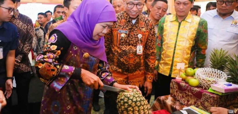 Khofifah indar parawansa memotong buah nanas dalam Misi Dagang Jatim Lampung