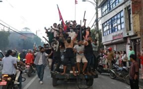Para pengunjuk rasa membawa bendera nasional Nepal sambil menaiki truk polisi di luar Istana Presiden di Kathmandu pada 9 September 2025, sehari setelah polisi menindak demonstrasi terkait larangan media sosial dan korupsi yang dilakukan pemerintah. Presiden Nepal menyerukan persatuan nasional pada 9 September, AFP/Prabin RANABHAT / AFP