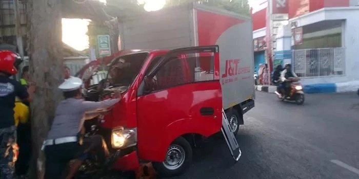 Sebuah truk boks merah milik perusahaan ekspedisi menabrak pohon di pinggir jalan kota probolinggo Senin (20/10/2025) pagi