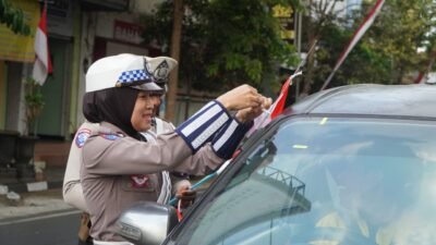 Satuan Lalu Lintas (Satlantas) Polres Malang dalam menyemarakkan Hari Ulang Tahun (HUT) ke-81 RI Dengan bagikan bendera ke warga